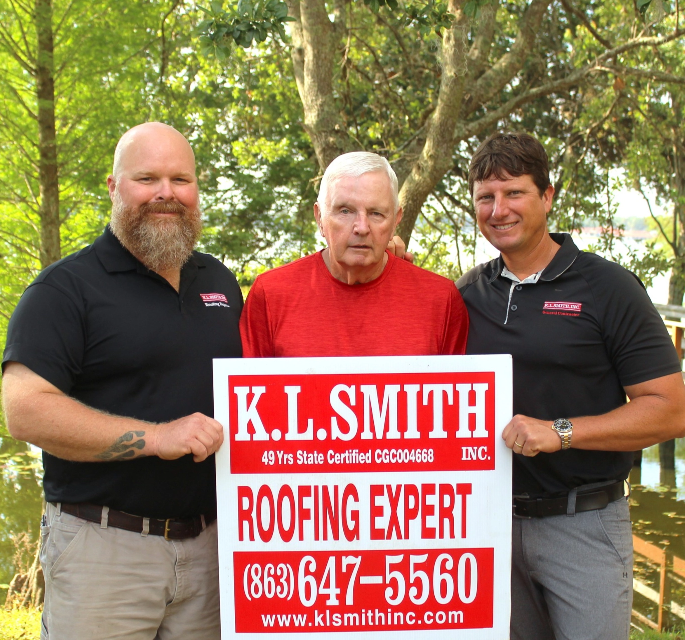 Ken, Ryan, and James, posing with the KL Smith Roofing Expert Lawn Sign. 