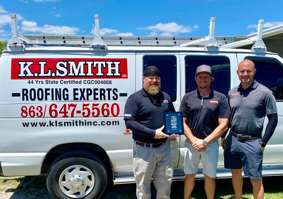 Lakeland's K.L. Smith Roofing team with a service award, showcasing their dedication to quality roofing solutions in Florida's demanding weather conditions.